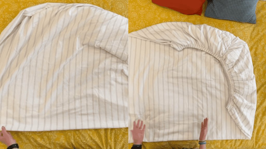 fitted sheet neatly folded on bed with striped fabric smoothed and elastic corners tucked into a clean shape