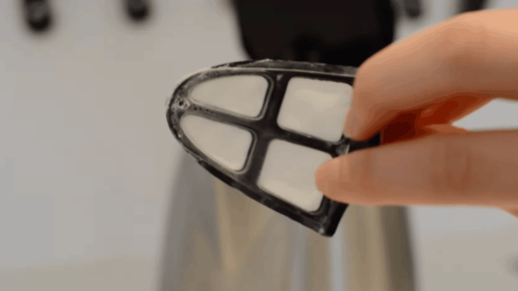 hand holding electric kettle filter ready to soak in vinegar