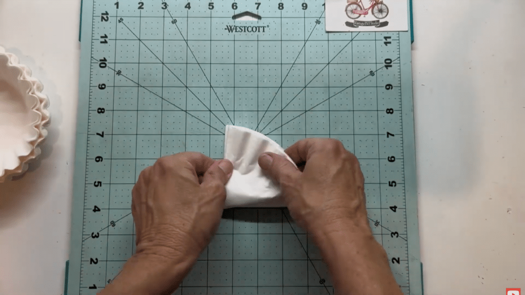 hands folding stacked coffee filters on cutting mat