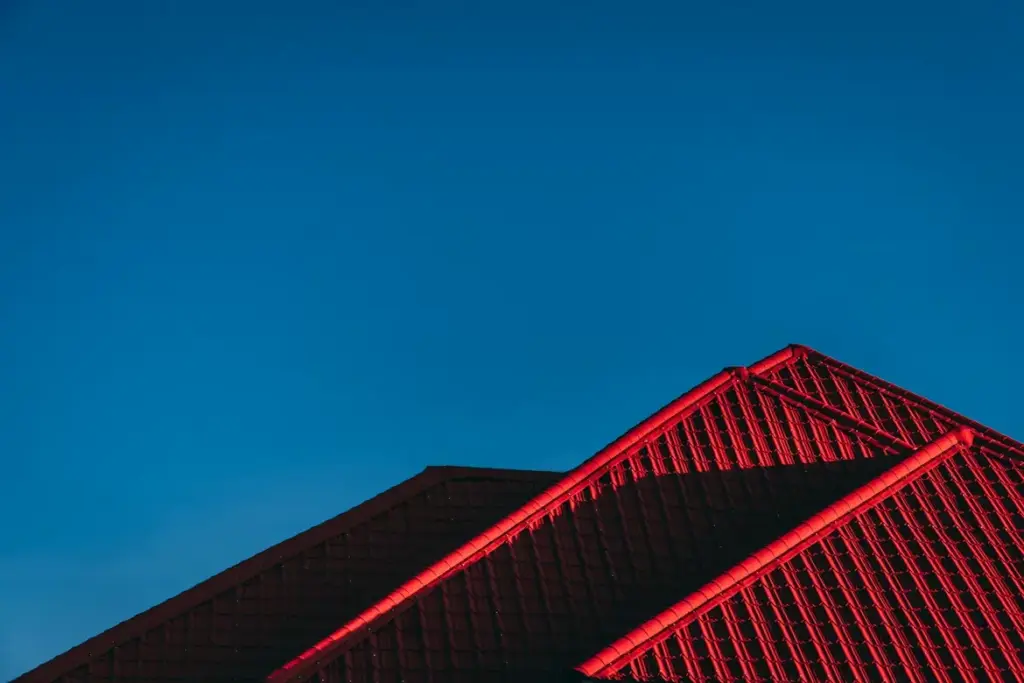 Home Harmony: Why a Healthy Roof Means a Healthy Home Red roof architecture against clear blue sky at dusk