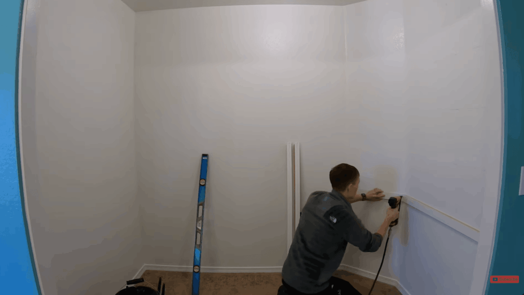 installing shelf supports by marking studs on the wall and nailing supports in place