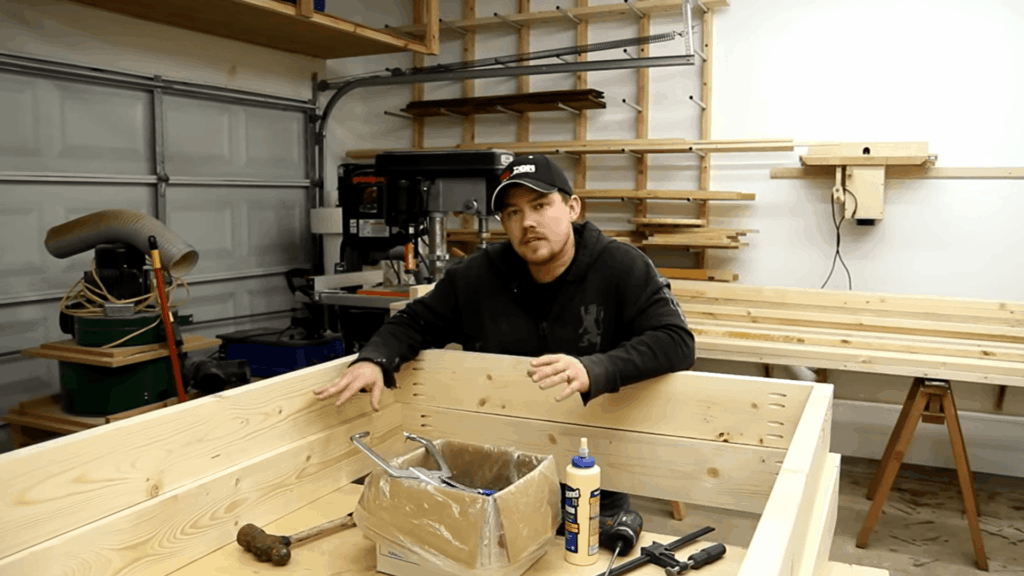 man building wooden frame in workshop using tools and boards for diy bunk beds project