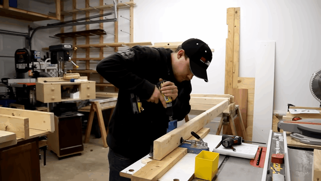 man drilling wooden frame in workshop building diy bunk beds with tools and lumber setup