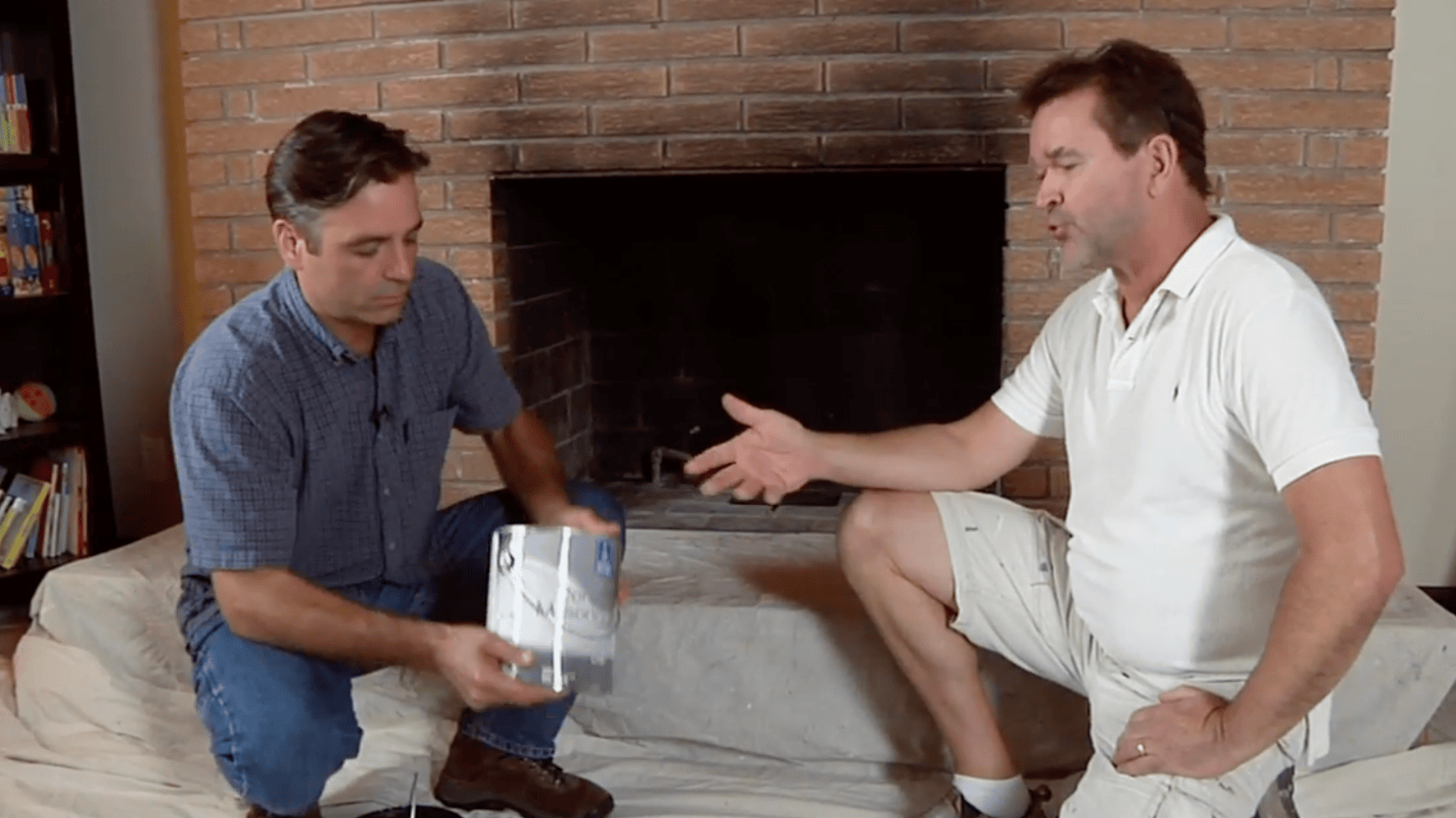 man holding paint can near brick fireplace to choose the right primer and paint
