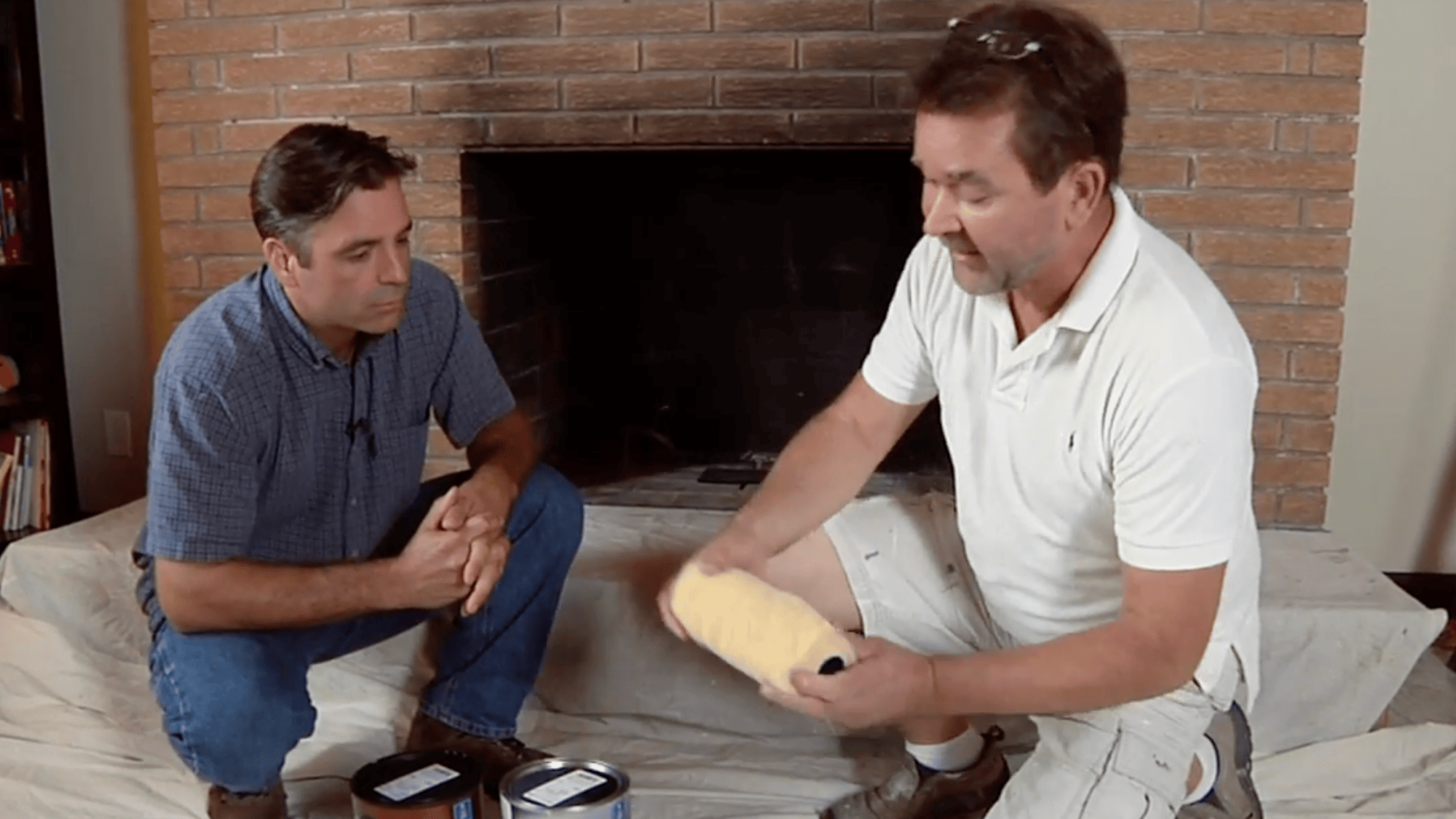 man showing paint roller near brick fireplace to use the right roller for brick