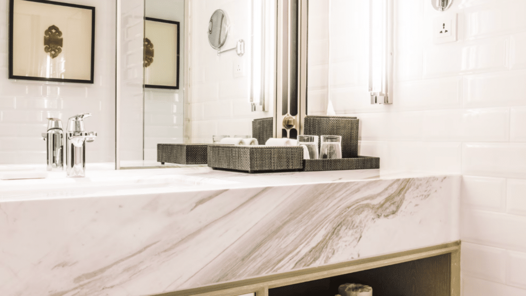 marble statement bathroom design with bold veined countertop mirror lighting and elegant finishes