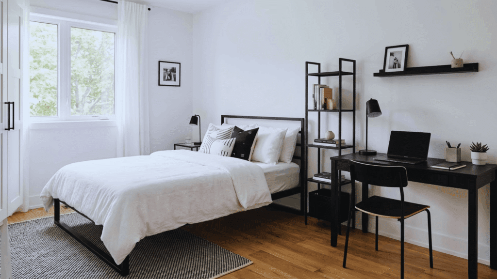 minimal black and white teen bedroom with desk shelves and natural light