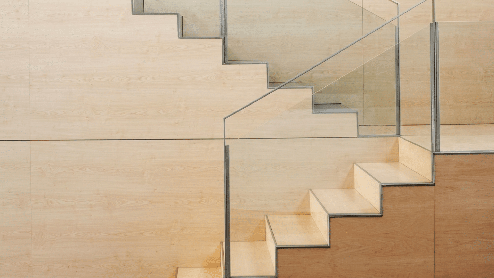 minimal wooden  half turn flight of stairs with glass railing indoors