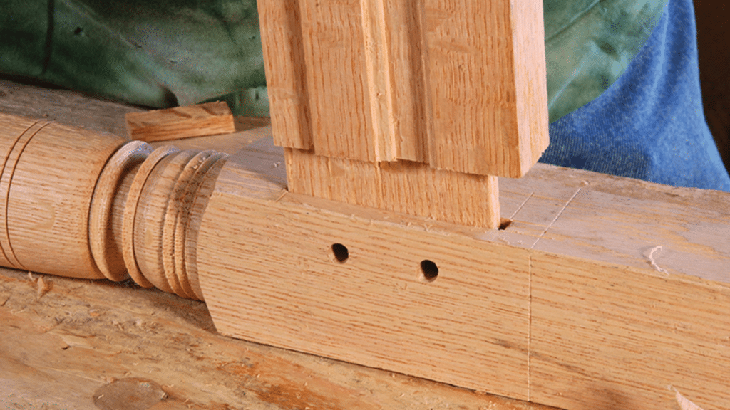 Mortise and Tenon: Which Should You Make First? mortise and tenon joint being fitted into wooden beam during woodworking showing precise wood connection