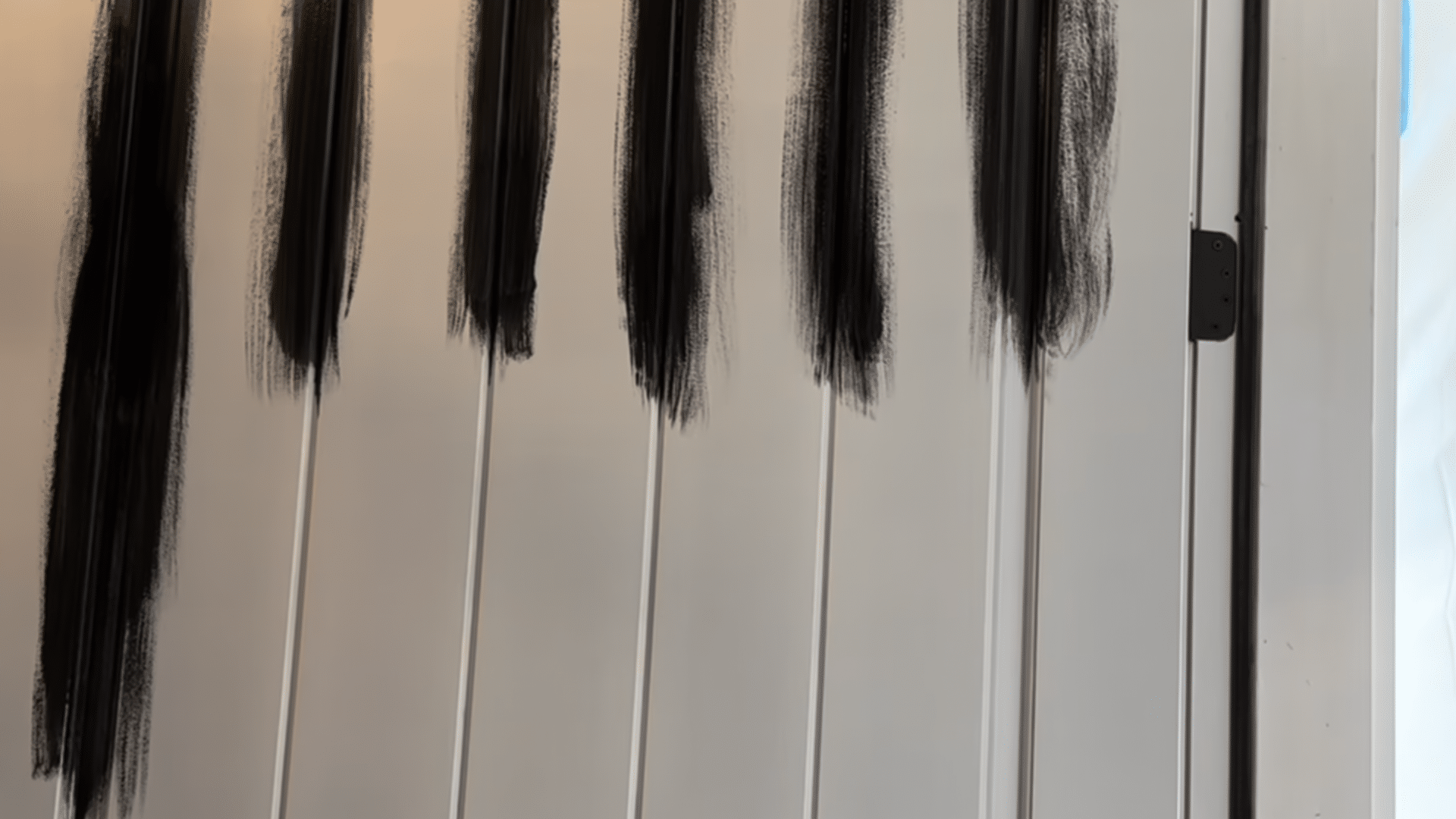 painting front door black showing first coat of black paint applied to wooden door panels