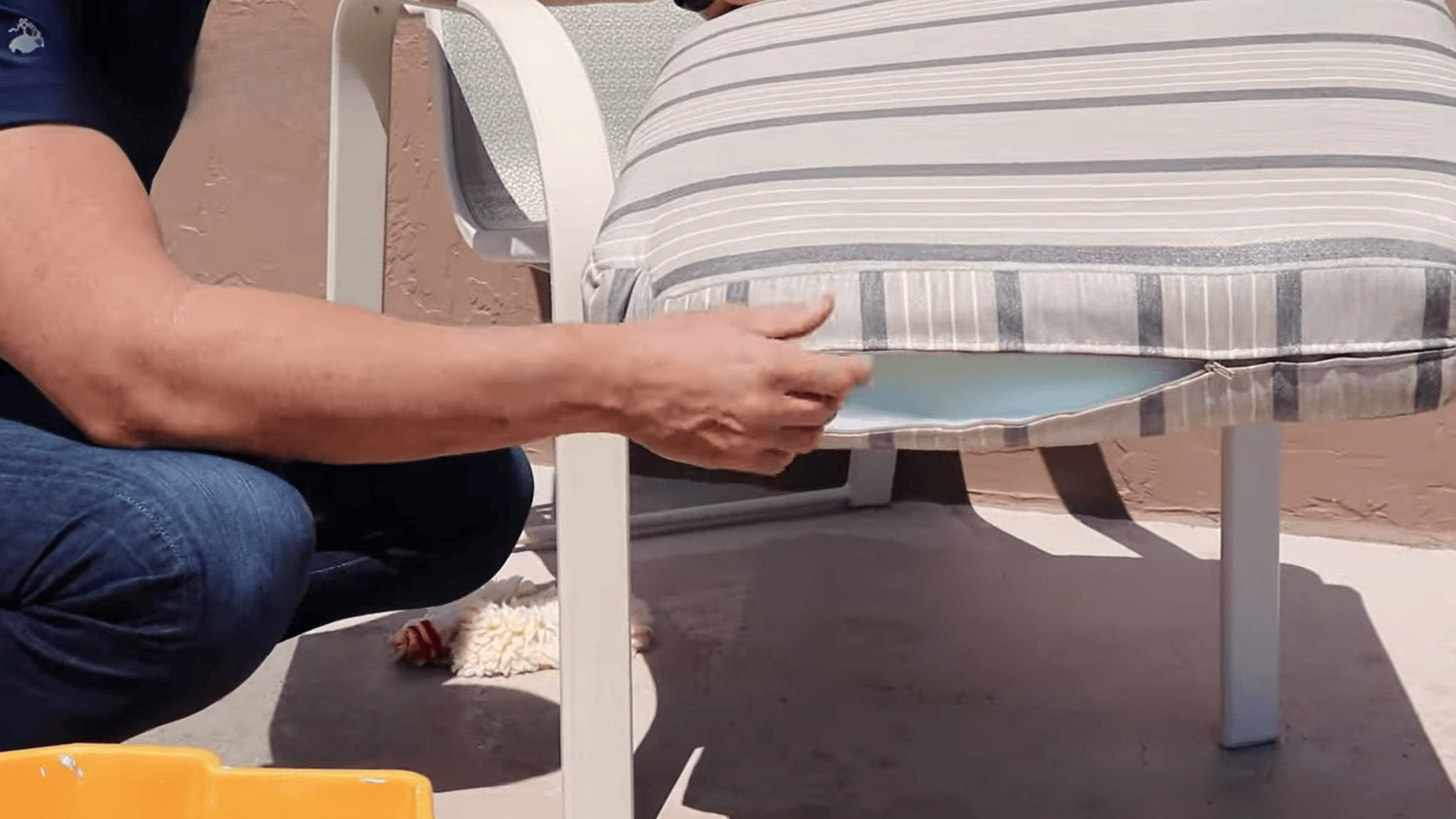 person adjusting and placing cleaned outdoor cushion back on chair showing how to clean sunbrella cushions after washing and drying (2)