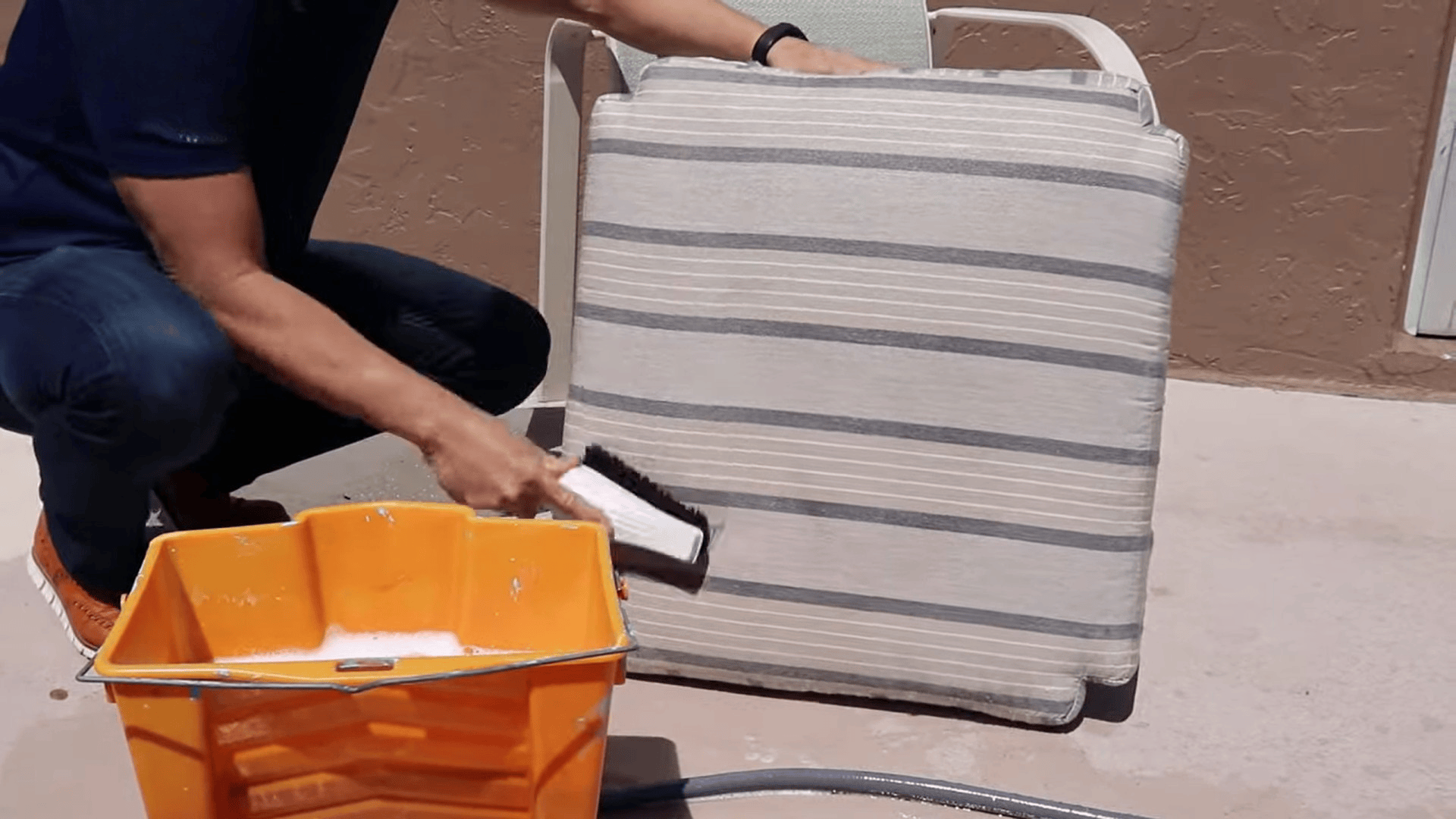 person adjusting and placing cleaned outdoor cushion back on chair showing how to clean sunbrella cushions after washing and drying (1)