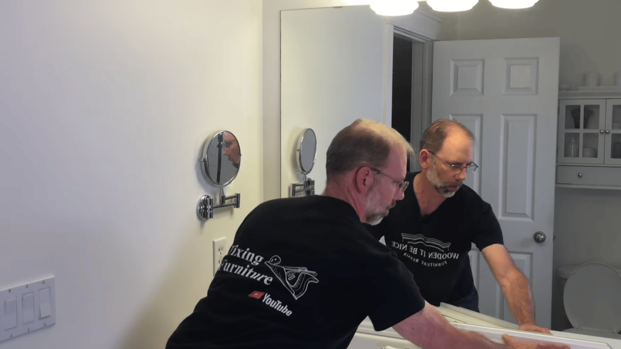 placing trim pieces onto mirror surface and pressing them in place to form frame around mirror edges