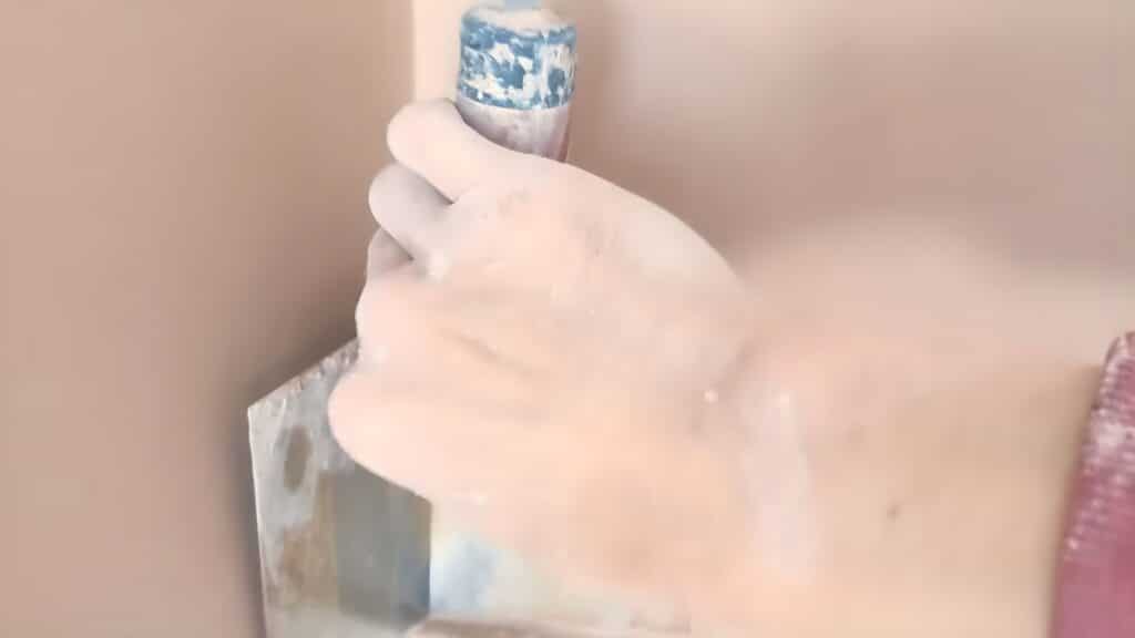 smoothing plaster wall with light strokes refining surface and filling small imperfections evenly