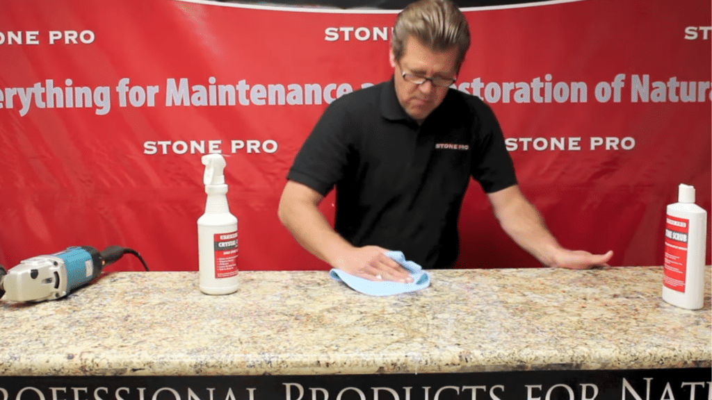 wiping granite surface with microfiber cloth during how to polish granite countertops for a clean streak free finish