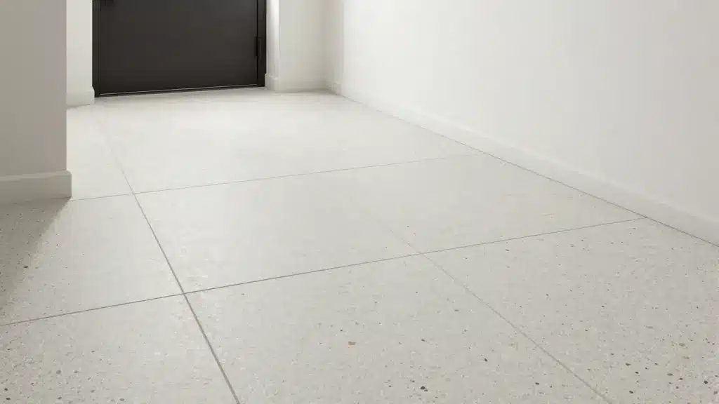 Light-colored terrazzo-look porcelain floor tiles with gray and tan flecks in a contemporary, bright foyer