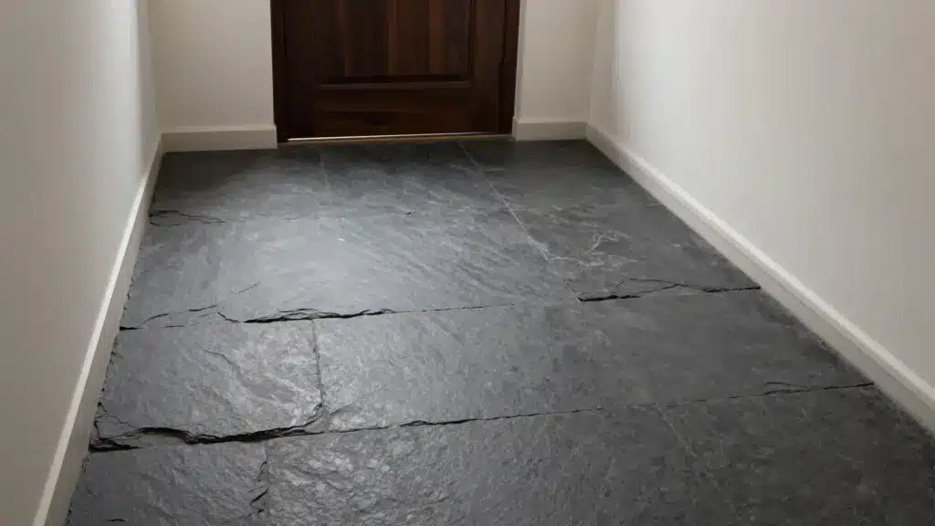 Natural dark charcoal slate floor tiles with a textured finish in a rustic, mountain-inspired home entryway