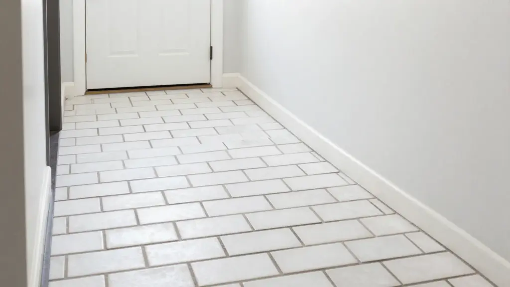 White subway tiles with bold dark grout lines creating a clean, graphic look on a modern home's entryway floor
