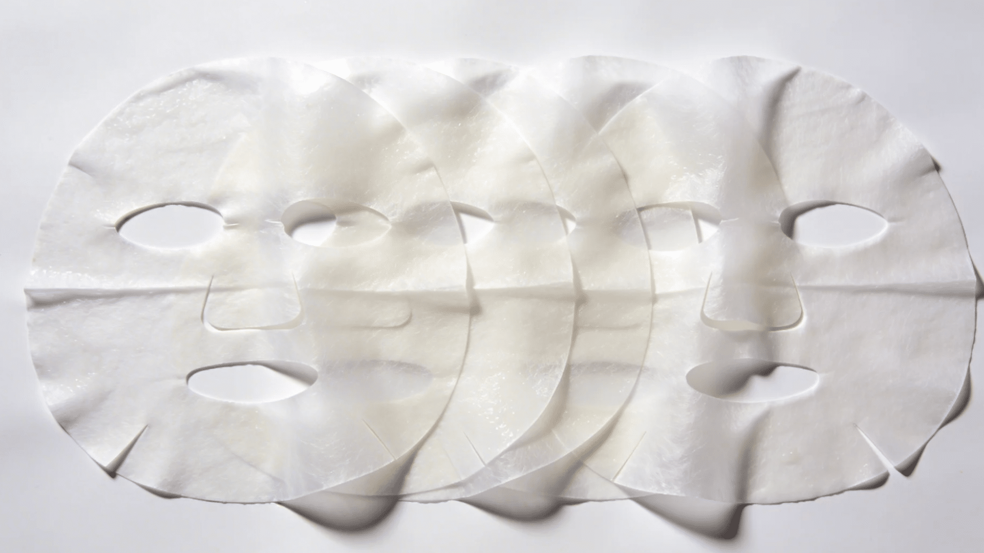 a set of sheet face masks neatly arranged in overlapping layers on a clean surface for favorite things party gift ideas