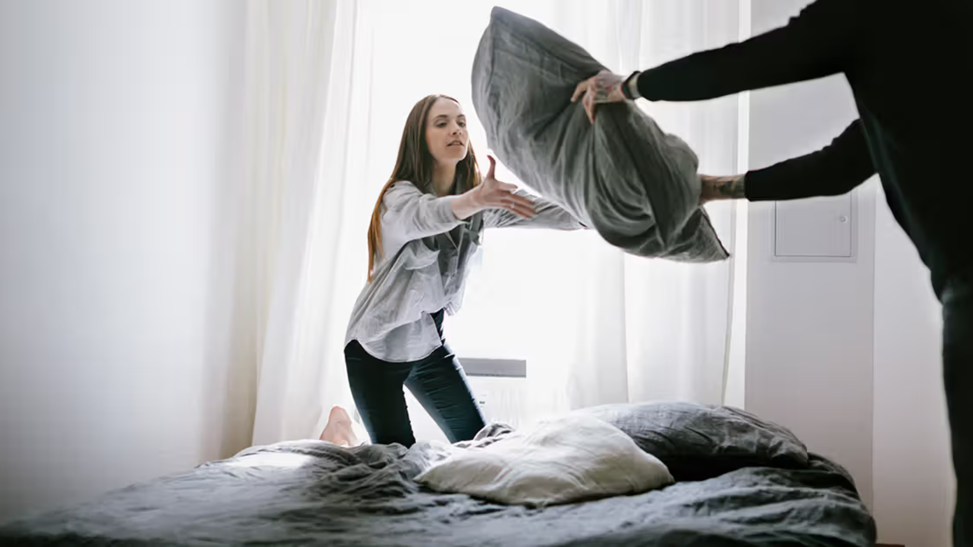 arranging pillows and bedding during bedroom house cleaning routine