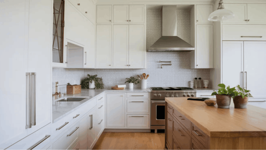 bright white kitchen with marble counters wooden island plants stainless stove clean modern design