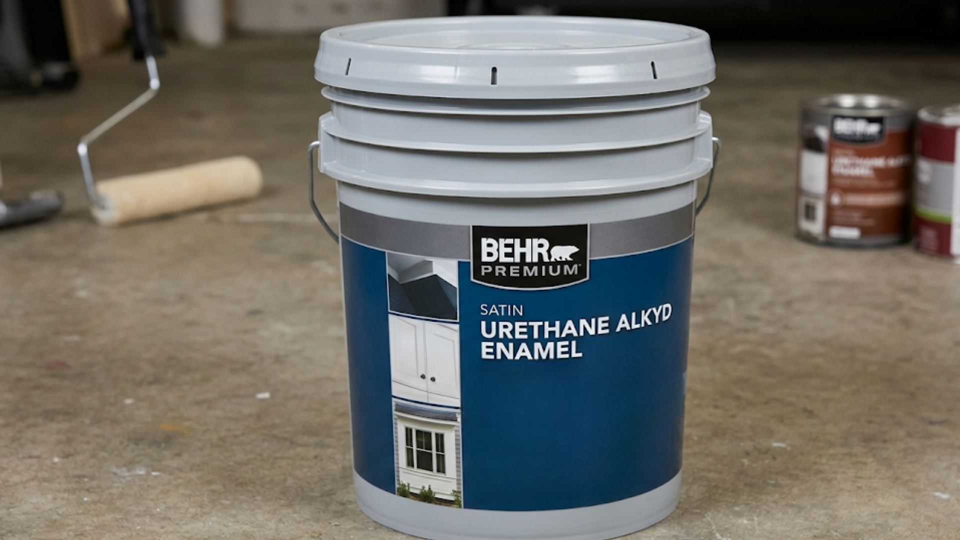 bucket of interior trim paint urethane alkyd enamel on workshop floor shown as best paint for doors and trim with rollers nearby