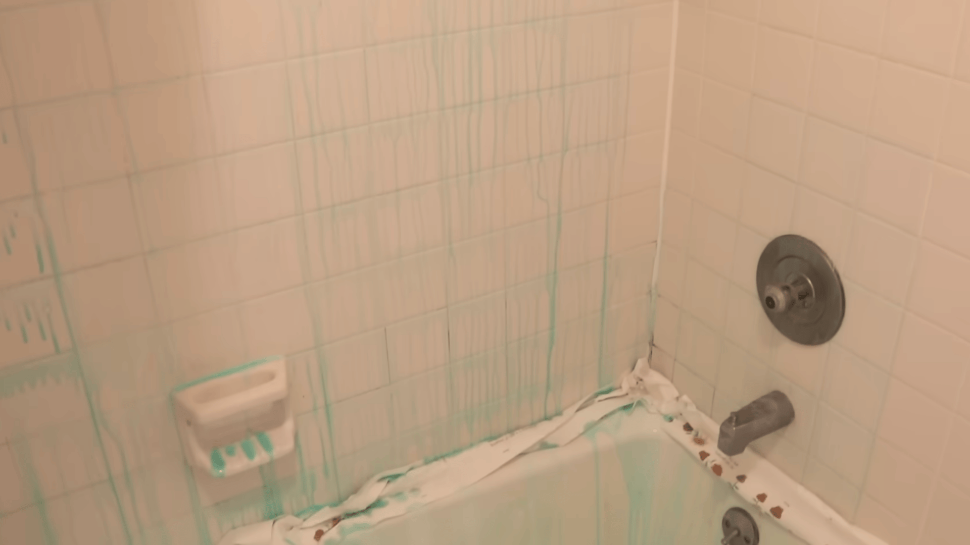 cleaning solution dripping down shower tiles and bathtub edges during mold removal process in bathroom