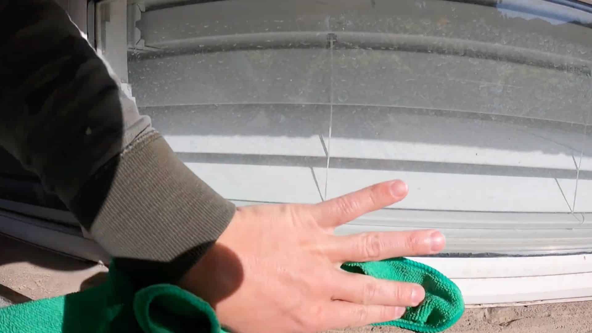 cleaning window frame surface to remove dust and debris before applying caulk for better sealing