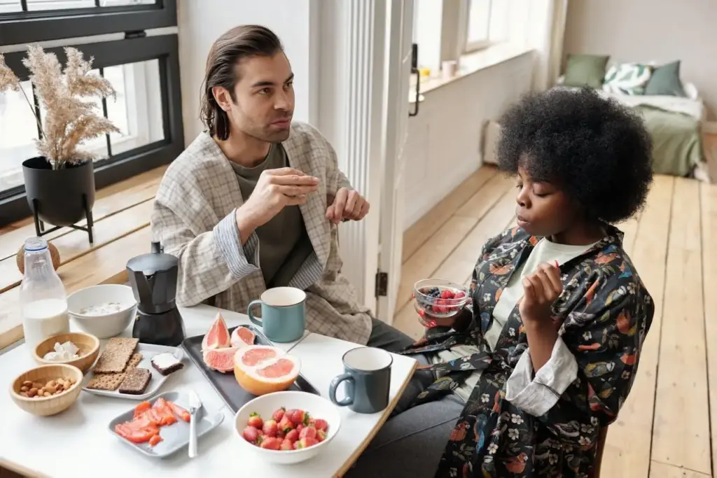 Couple enjoying breakfast with coffee and fruit in a bright, cozy dining area