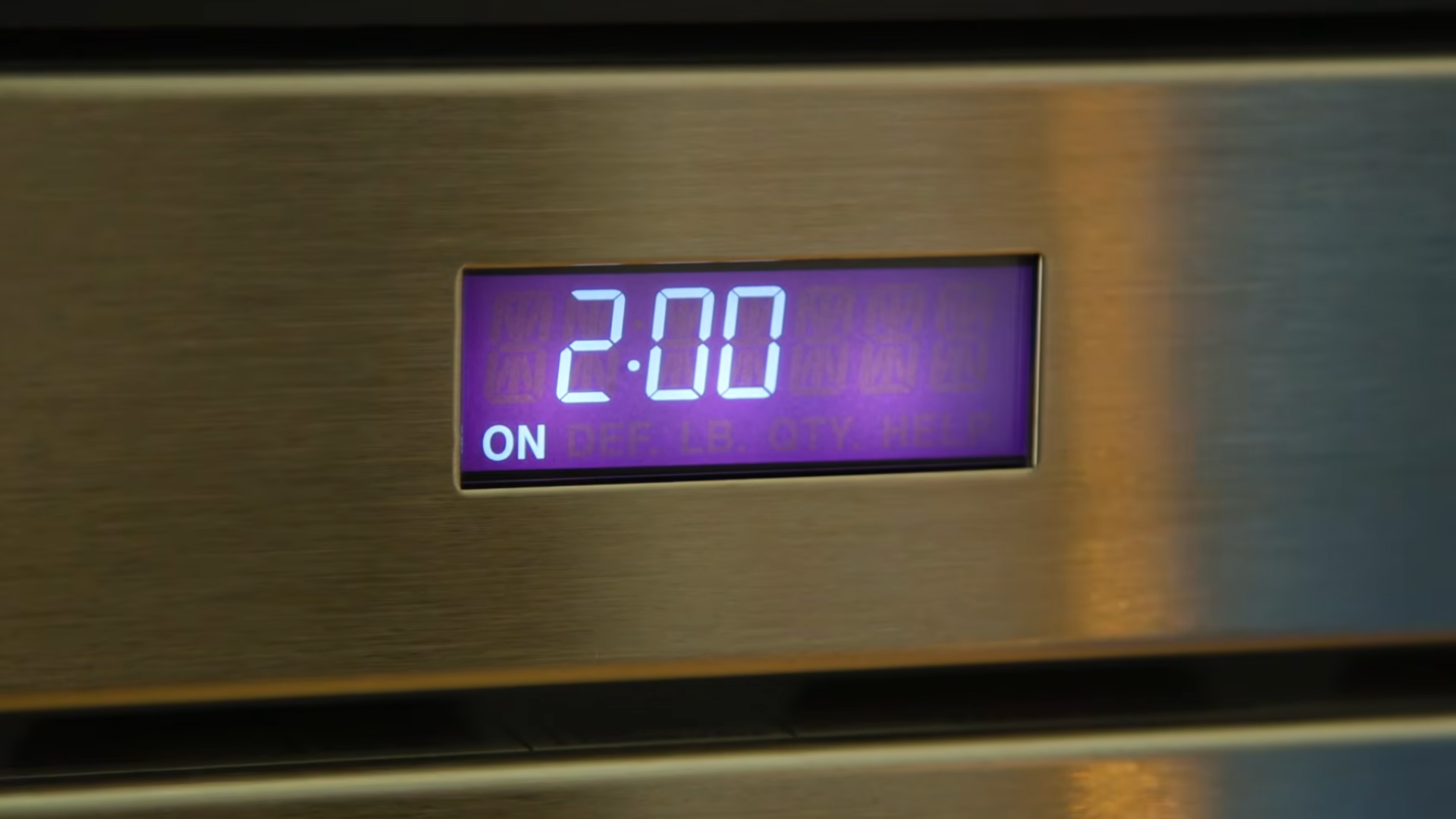 digital display on a stainless steel appliance showing a timer set to two minutes with illuminated purple numbers