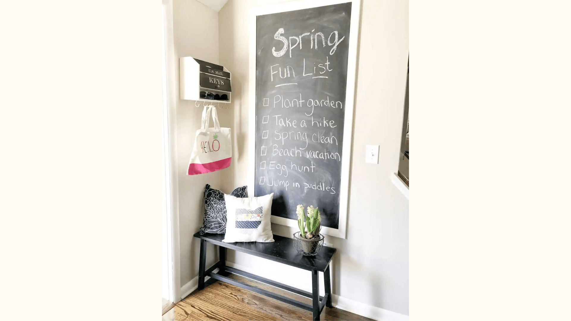 entryway bench with large chalkboard wall and small plant and pillows