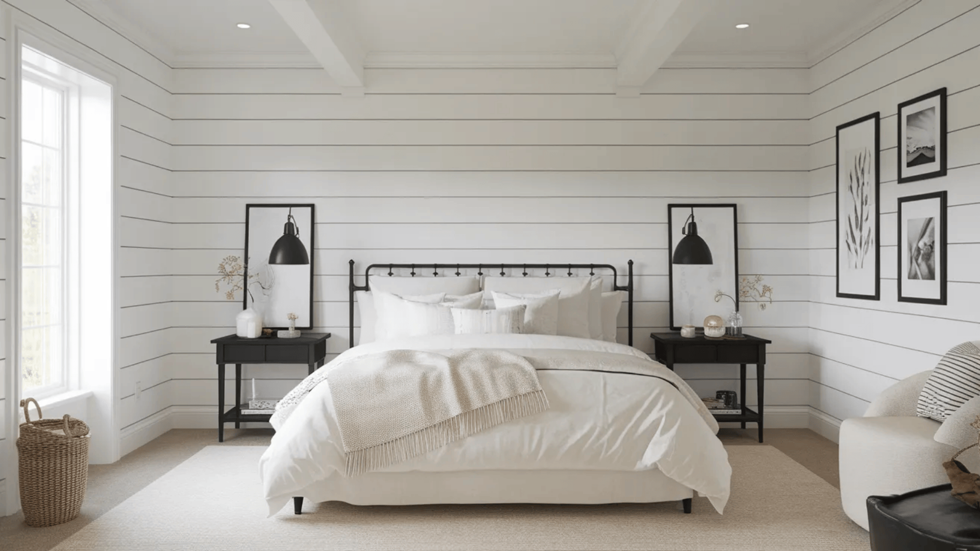 feminine black and white bedroom with shiplap walls plush bedding black nightstands and cozy armchair by window