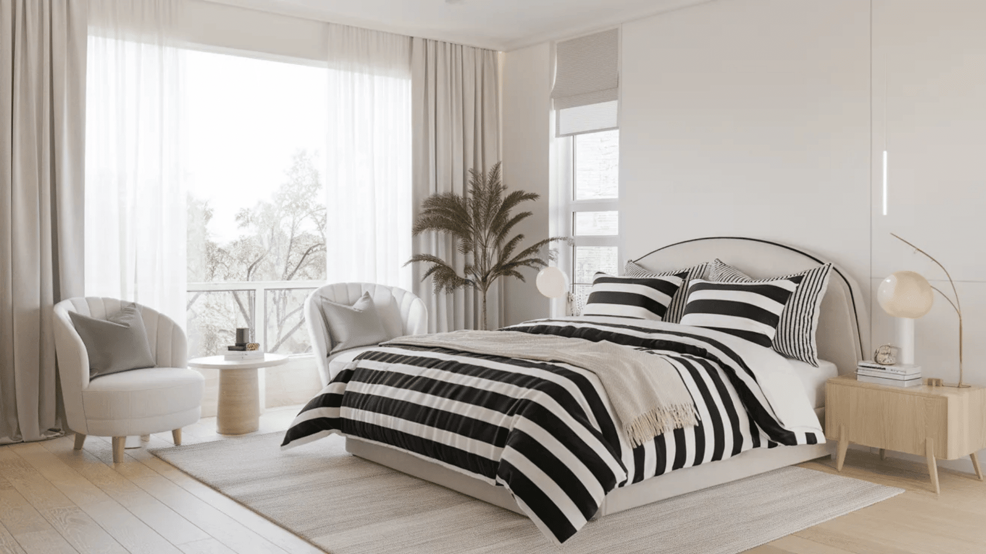 feminine black and white bedroom with striped bedding cozy throw two chairs and light wood nightstand by large windows