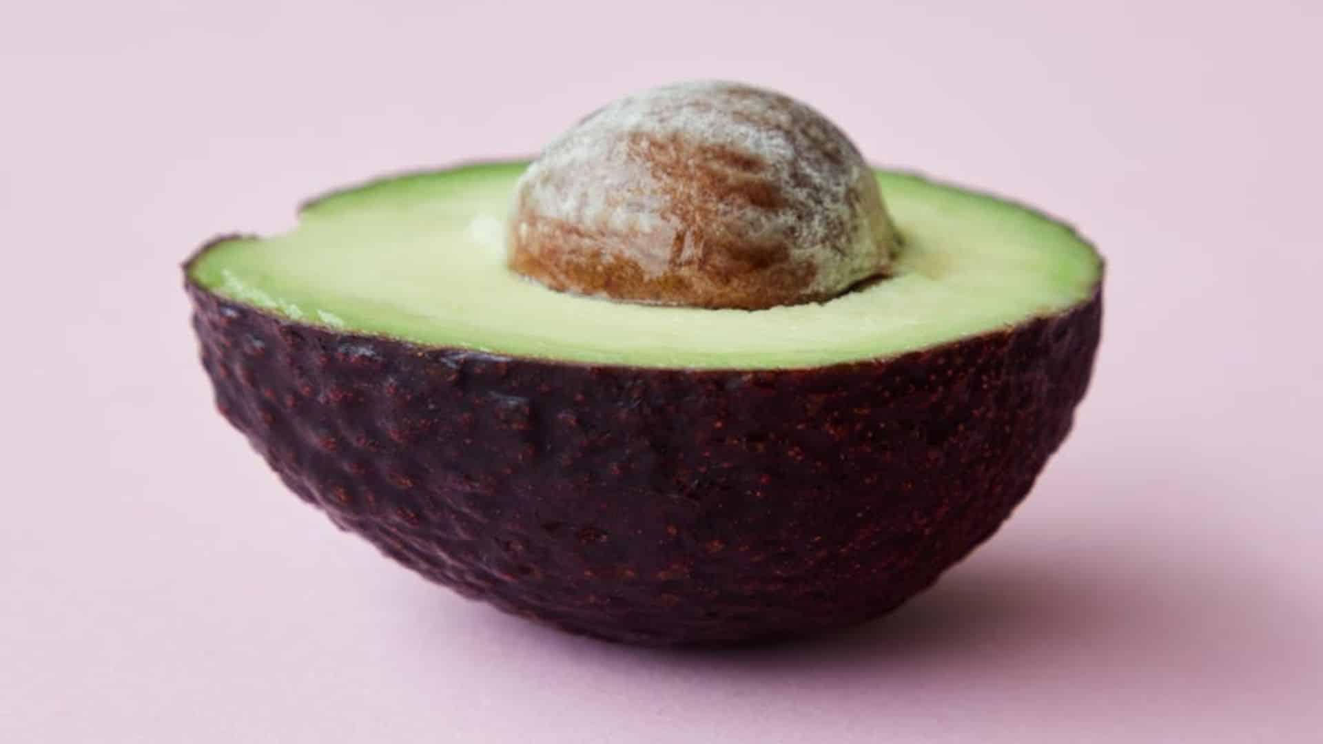 fresh avocado cut in half showing seed inside ready for how to grow avocado from seed process