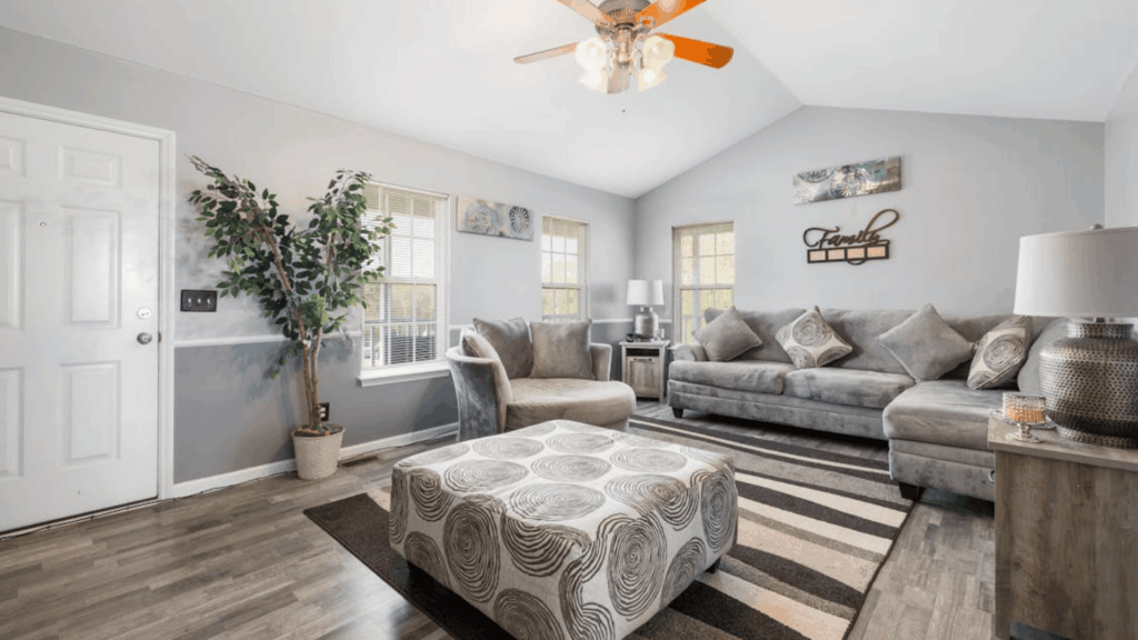 gray living room with sectional sofa patterned ottoman and striped rug modern home interior