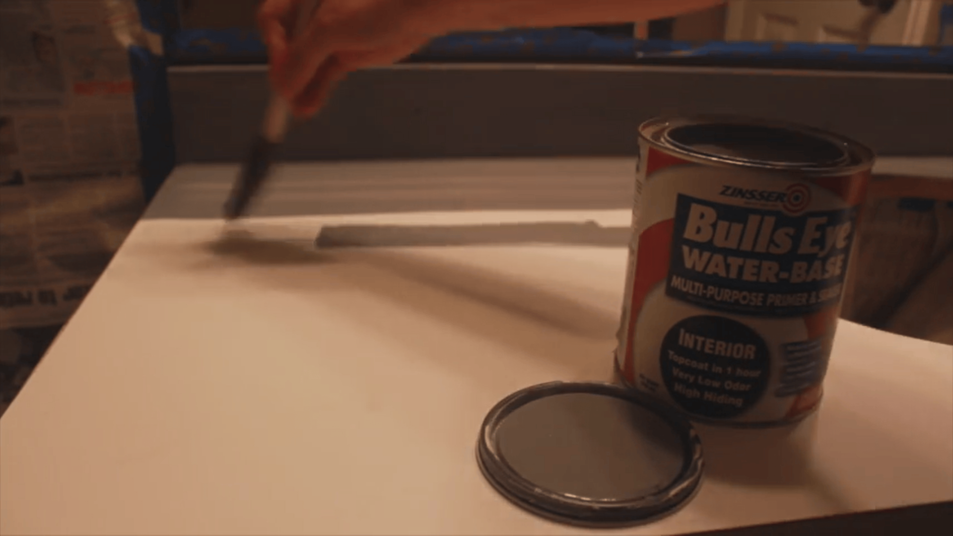 Hand applying primer with brush on countertop surface during resurfacing laminate countertops process