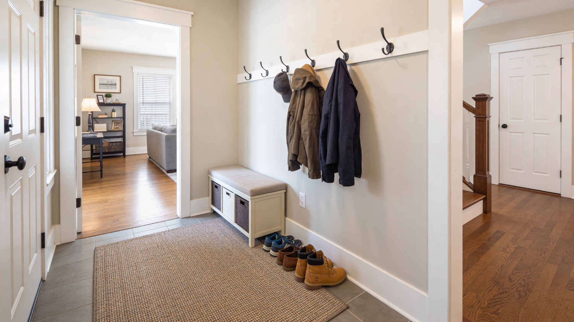 minimal entryway rug setup with bench hooks and shoe space