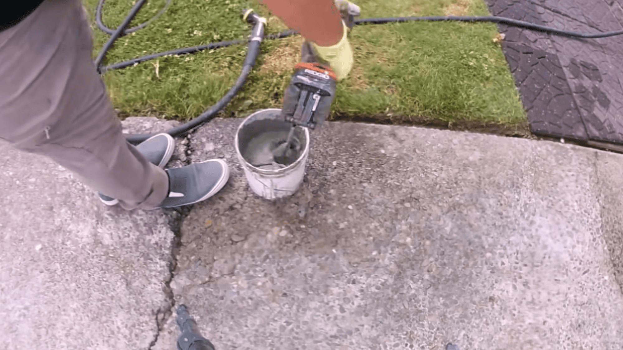 mixing cement repair mix to fill small cracks during concrete driveway resurfacing preparation