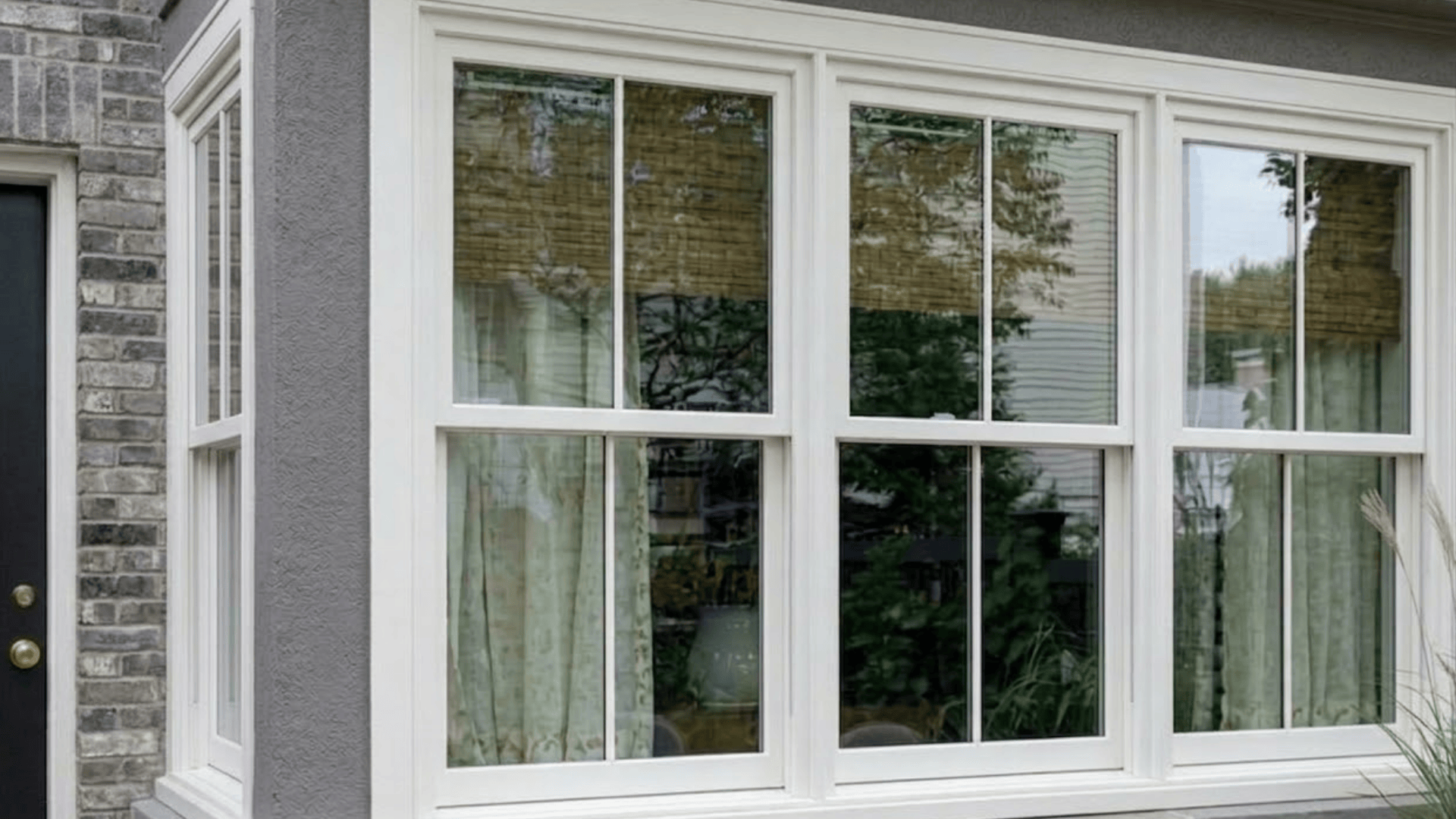 modern house exterior with white framed vinyl windows and curtains inside
