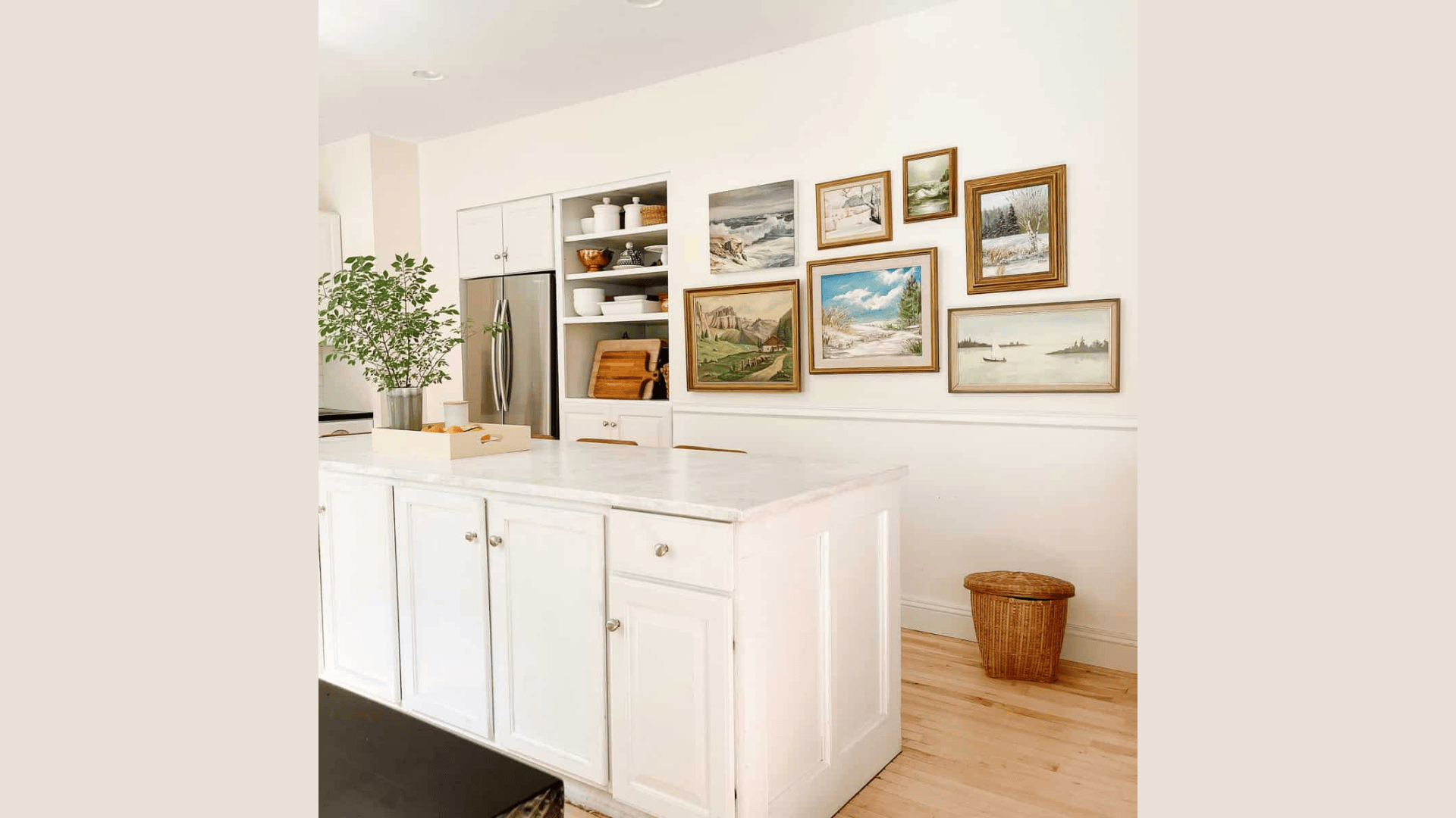 modern kitchen with white island gallery wall art and open shelves with dishes and wooden boards