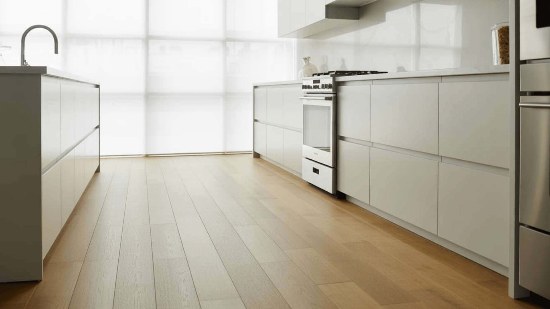 modern white kitchen with cabinets and light oak flooring displaying popular hardwood floor stain colors