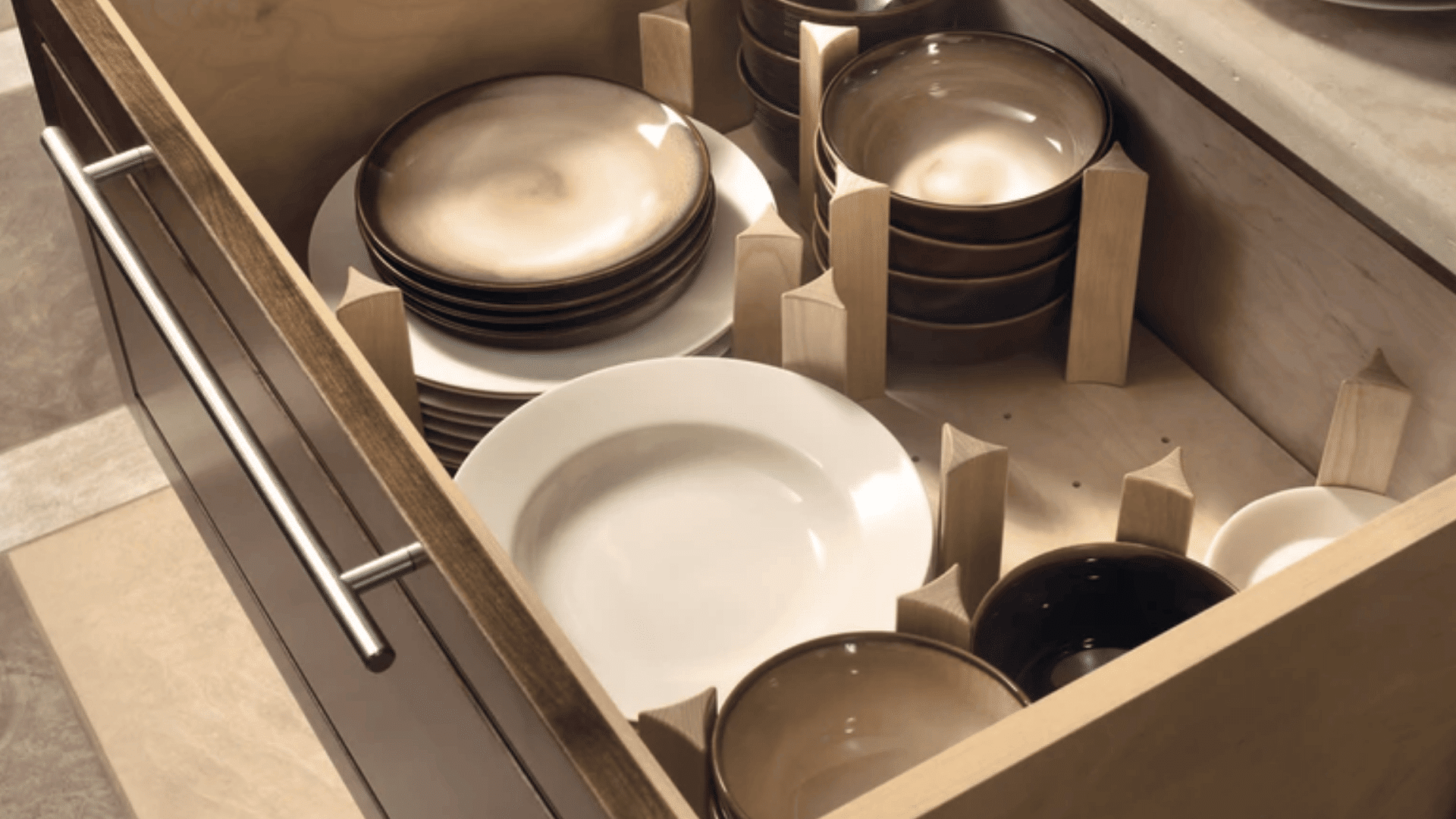 organized kitchen drawer with plates and bowls separated by dividers showing how to organize kitchen drawers neatly