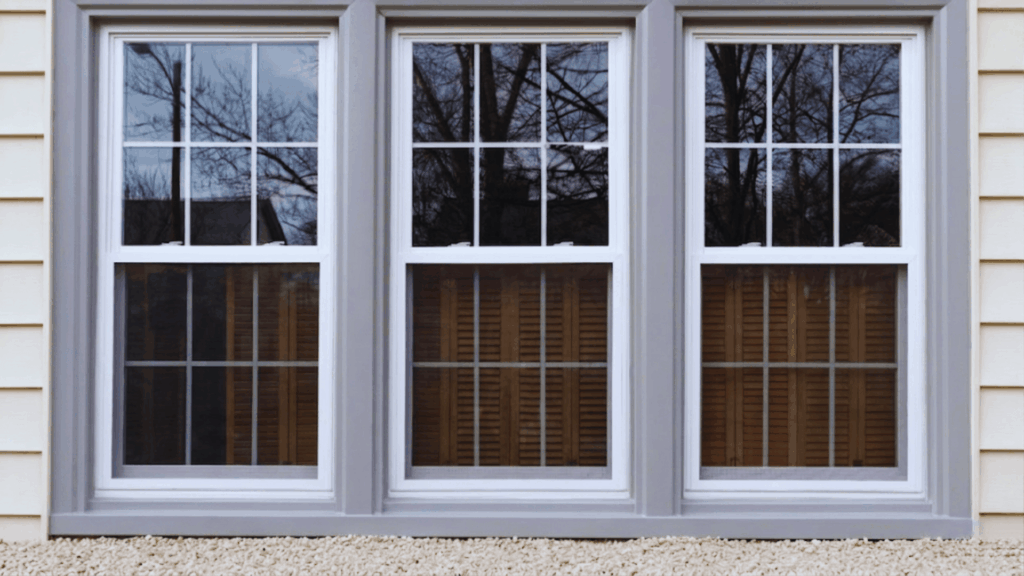 painting vinyl windows example on white house exterior with three window frames