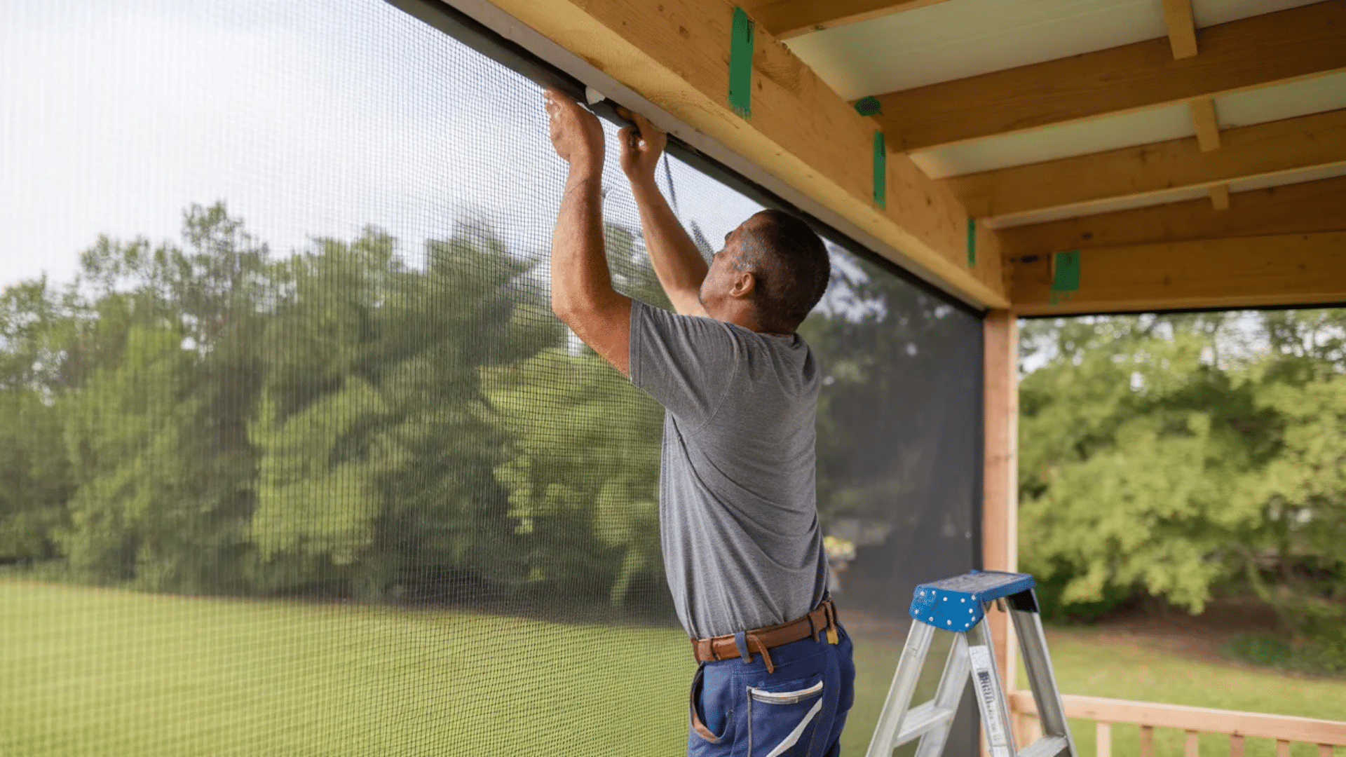 person installing mesh screen to protect porch area