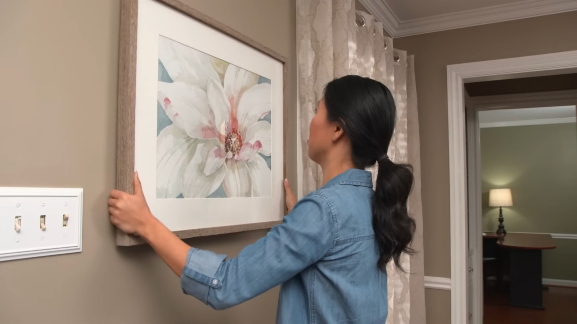 Placing and adjusting a picture frame on a wall to achieve correct alignment
