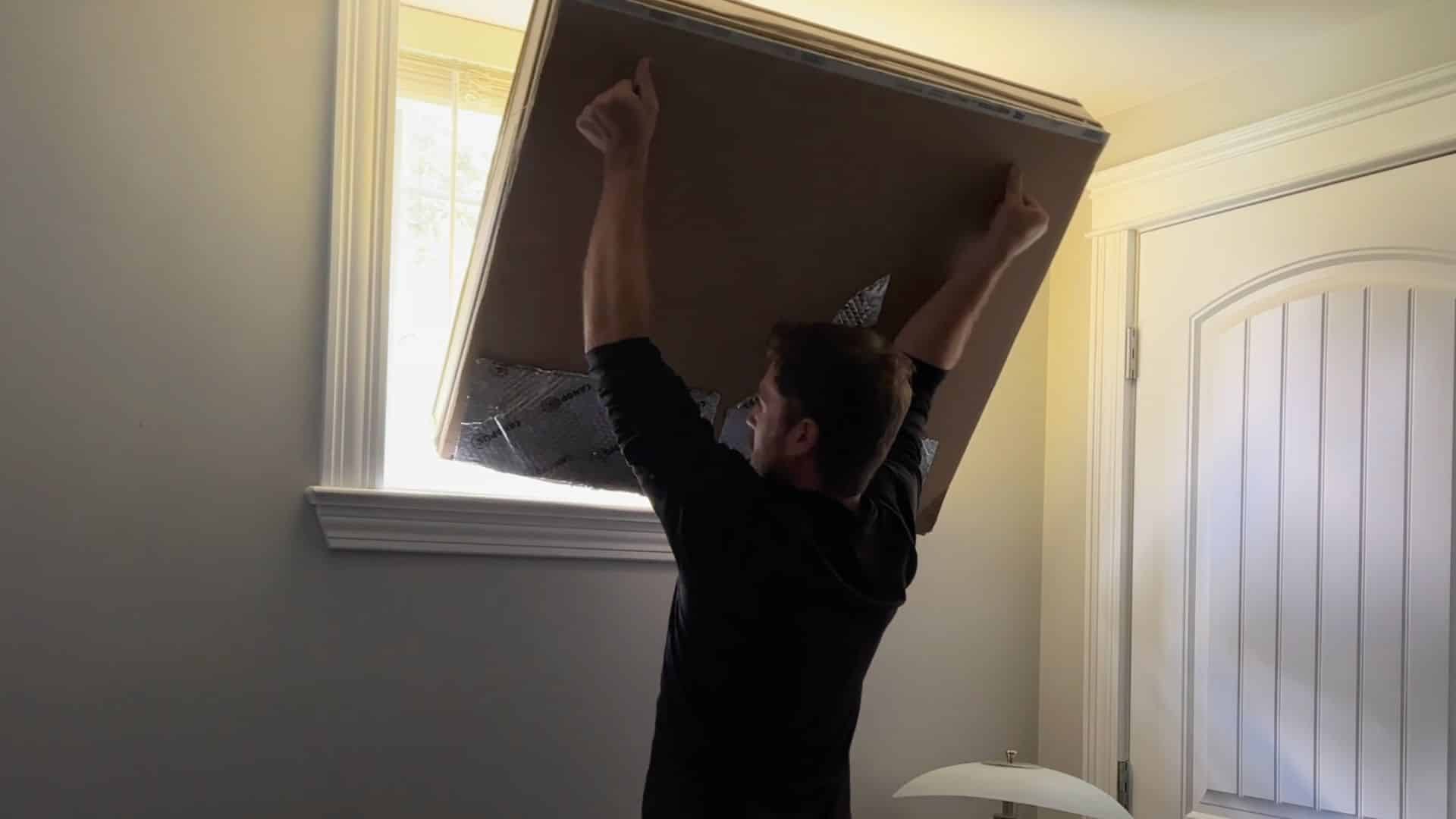 placing window plug into frame and checking edges to ensure tight fit and no light gaps for effective sound blocking