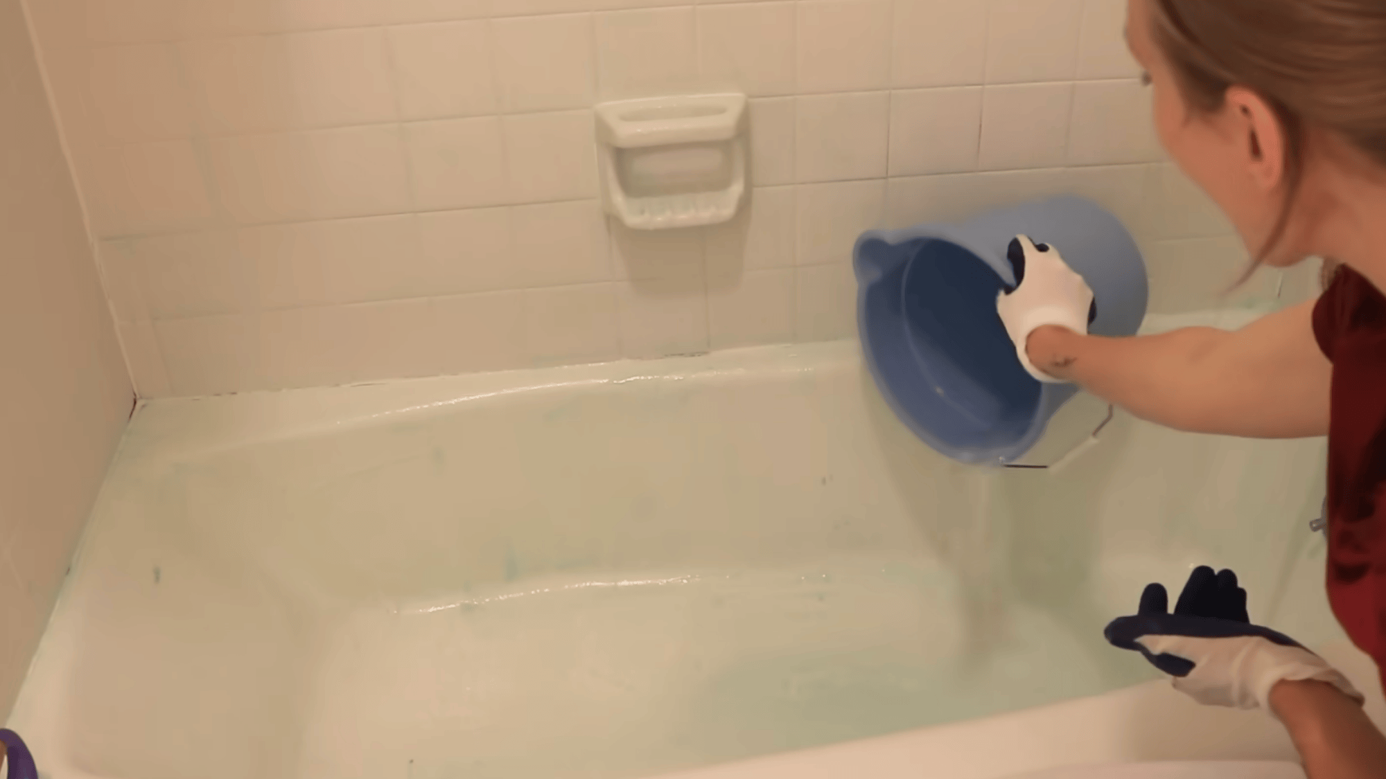 rinsing shower surface with water after cleaning mold