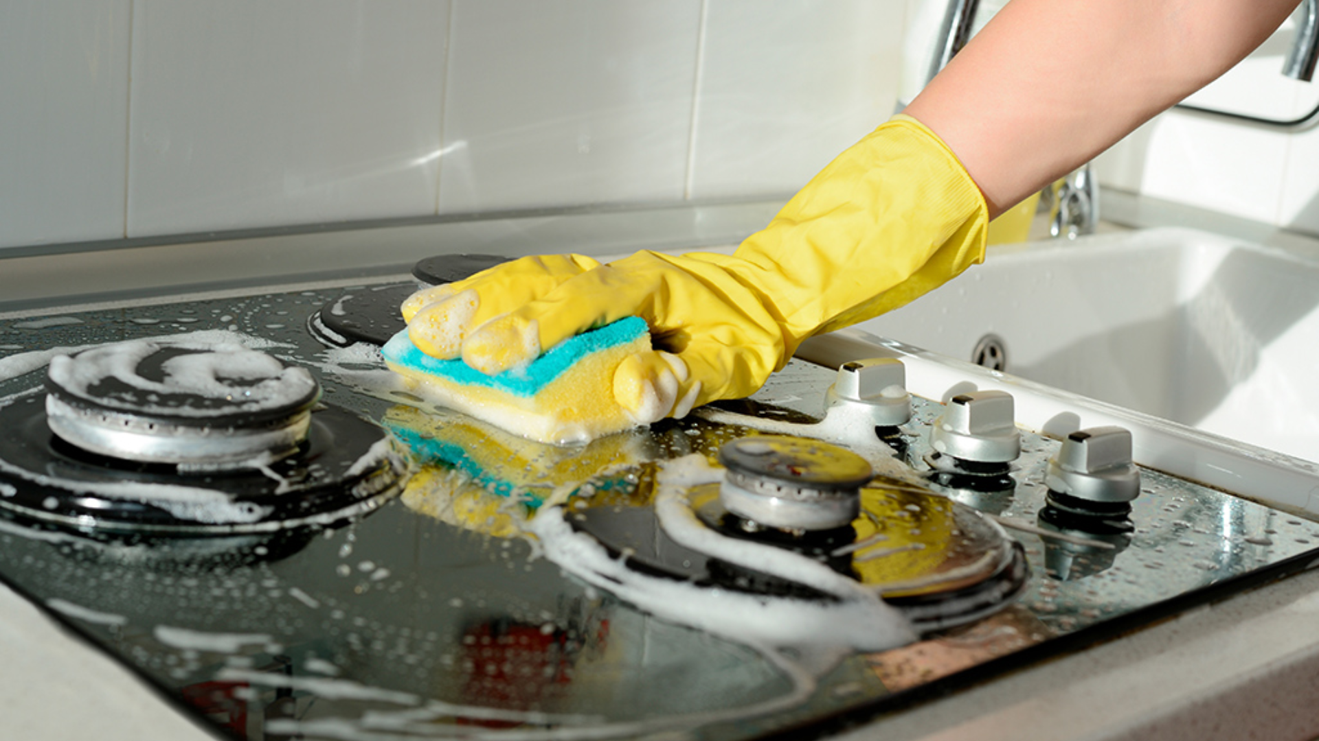 scrubbing kitchen stove during regular house cleaning routine