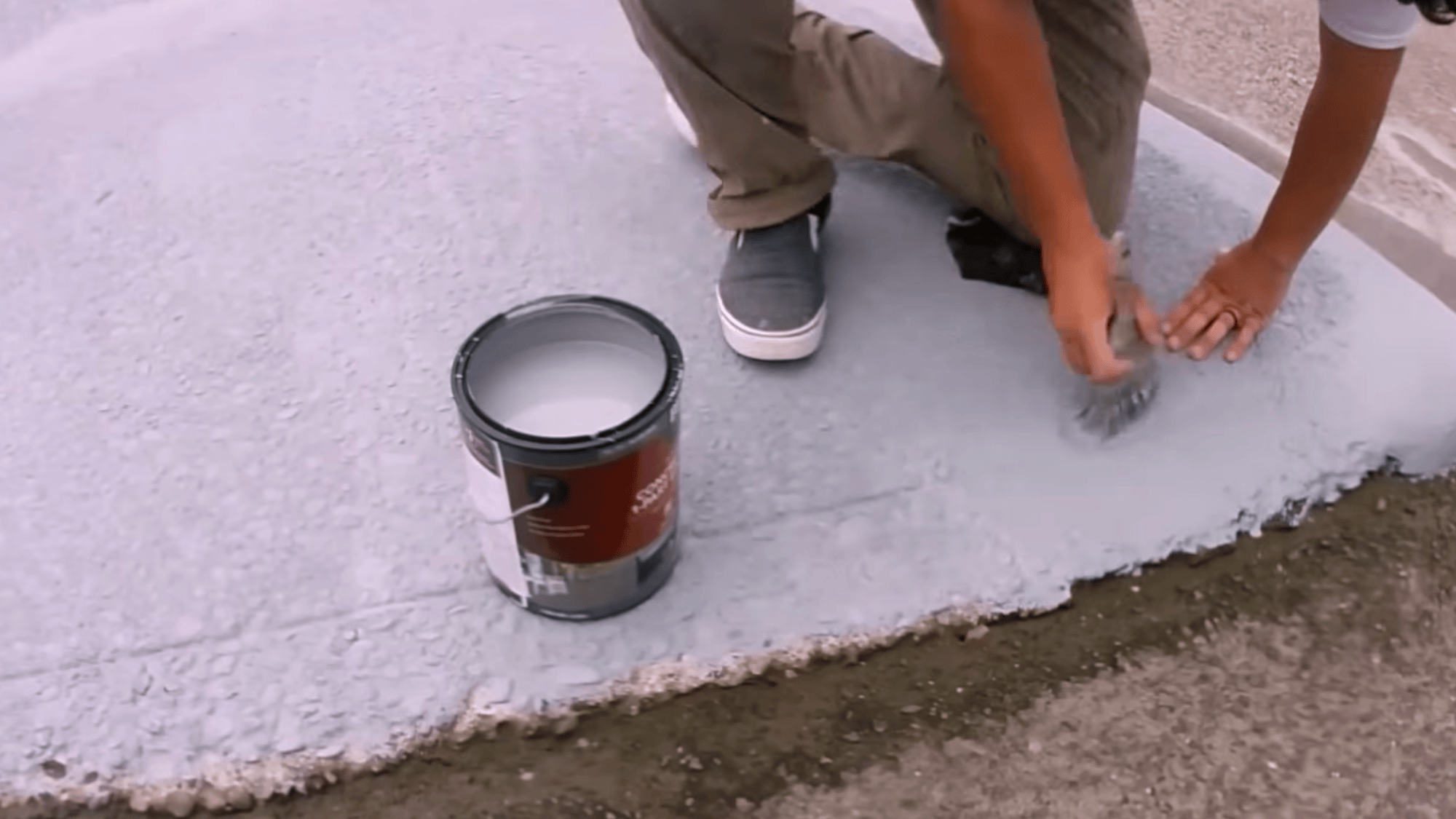 smoothing repaired driveway surface and applying epoxy during concrete driveway resurfacing process