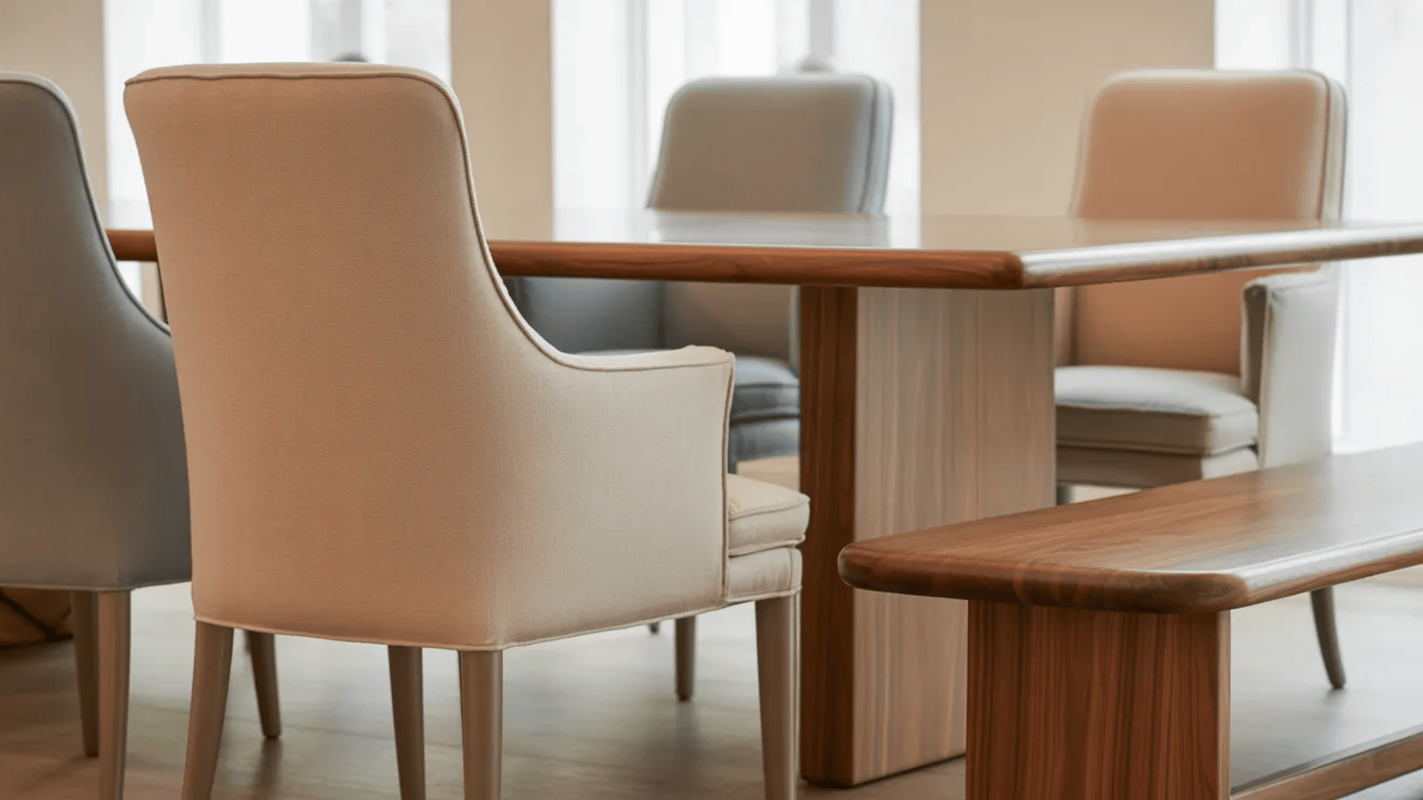 upholstered dining chairs and wooden table with bench seating arranged neatly inside a modern transitional dining room